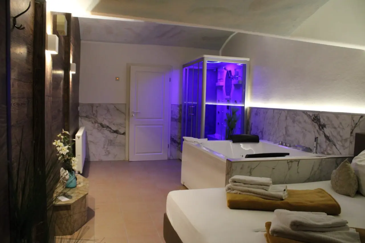 Whirlpool und moderne Dusche mit Farblicht in einem Wellness-Zimmer im Wellness-& Sporthotel 'Haus am See'.
