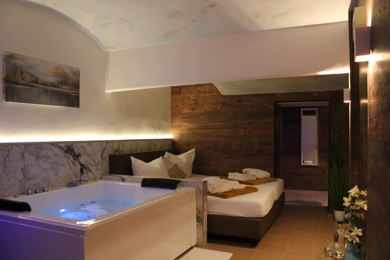 Whirlpool und Doppelbett in einem komfortablen Hotelzimmer im Wellness-& Sporthotel 'Haus am See'.