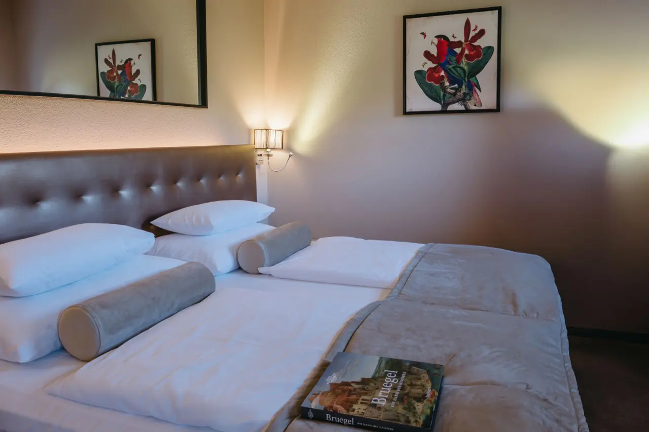 Gemütliches Doppelzimmer mit bequemen Betten und Kunst an der Wand im Hotel Schlafgut.