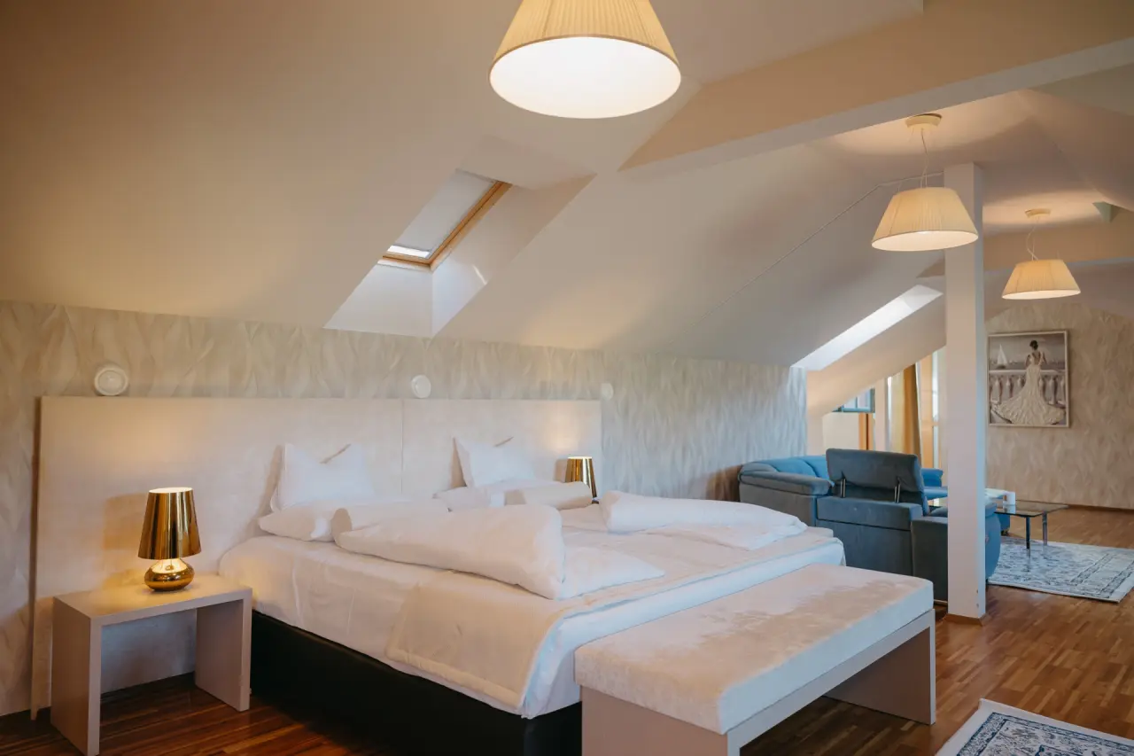 Dachgeschoss-Doppelzimmer mit gemütlichem Bett, Sitzbereich und Dachfenster im Hotel Schlafgut.