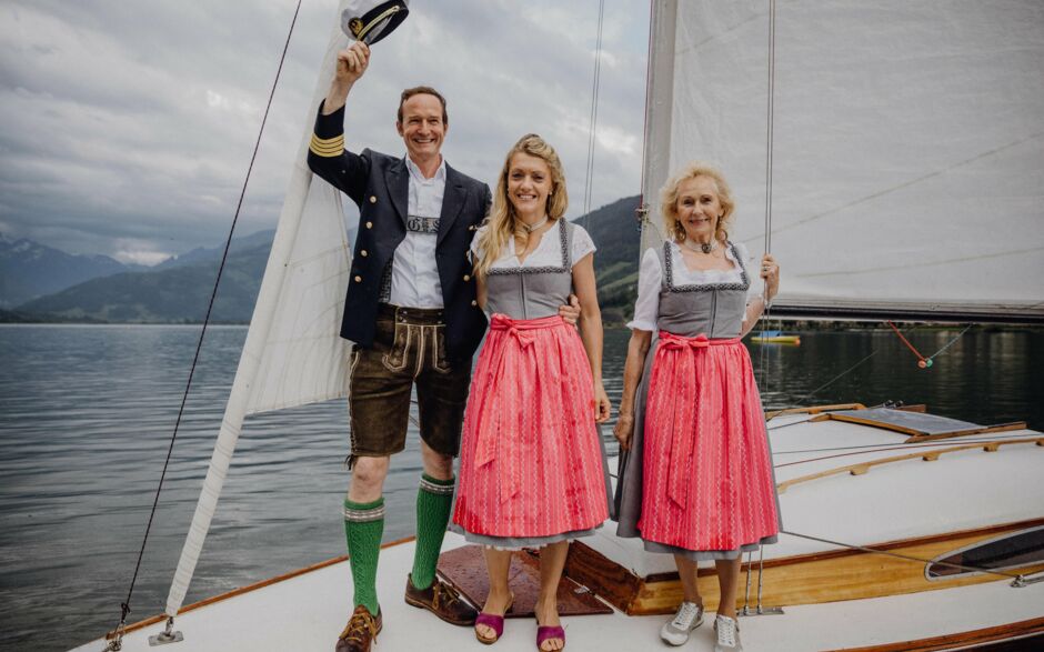 Sportresort Alpenblick in Zell am See – Familie in Tracht auf einem Segelboot am Zeller See | Wellnesshotel Salzburger Land