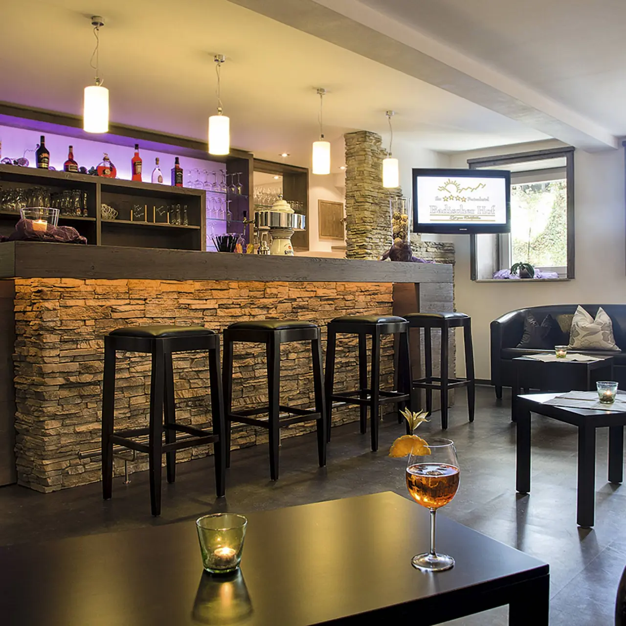 Hotel Badischer Hof in Biberach – Gemütliche Hotelbar mit Steinwand und Beleuchtung | Wellnesshotel Baden-Württemberg