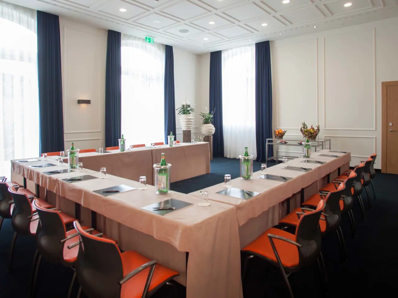 Konferenzraum im Kurhaus Cademario mit U-förmiger Bestuhlung, großen Fenstern und Tagungsausstattung.