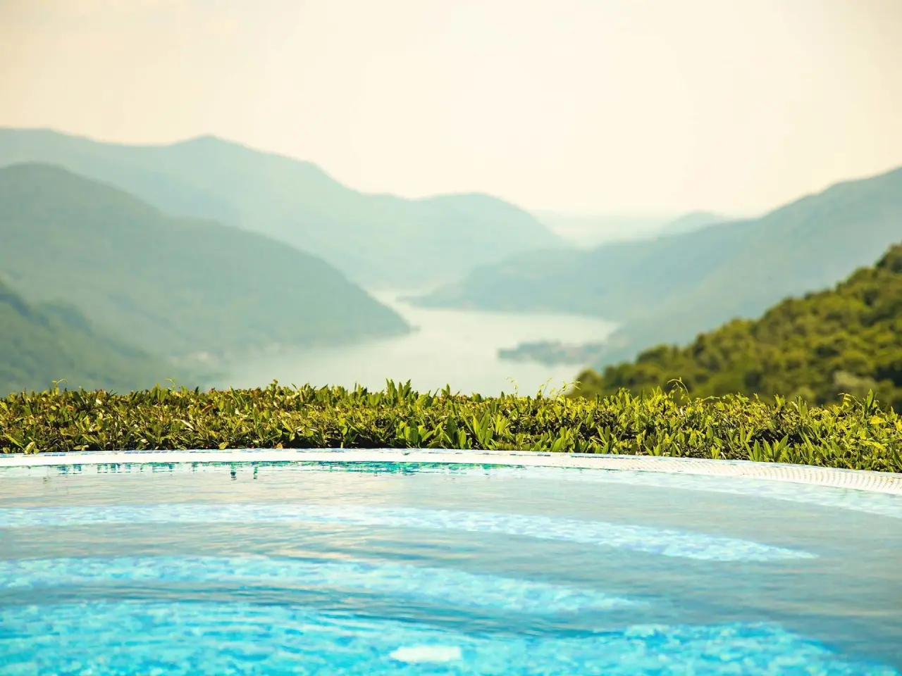 Infinity Pool mit Panoramablick auf den Luganersee und die Tessiner Alpen im Kurhaus Cademario Hotel.