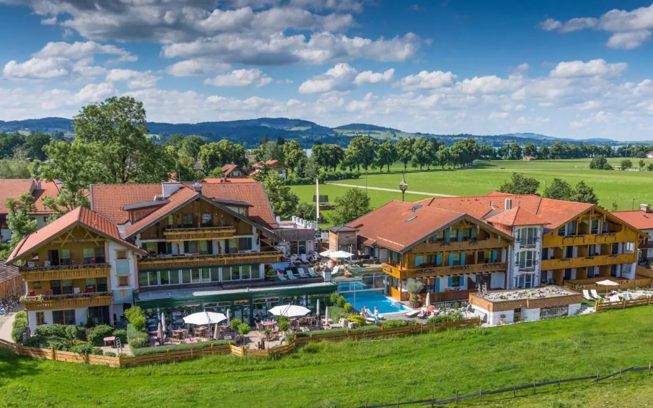 Luftaufnahme des Hotel Das Rübezahl mit traditioneller Architektur, Aussenpool und grüner Landschaft im Allgäu.