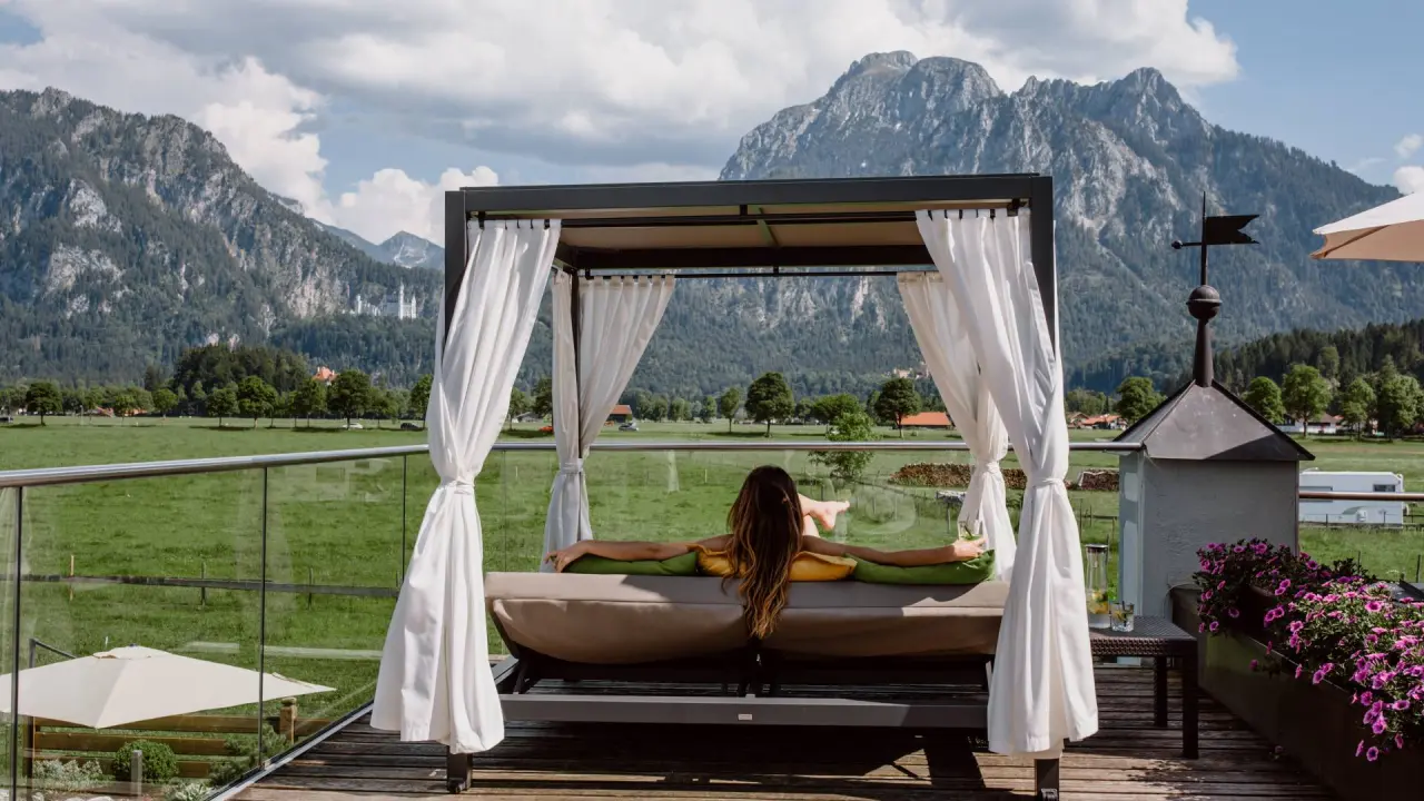 Entspannung auf der Sonnenterrasse im Daybed mit Bergblick und Schloss Neuschwanstein im Hotel Das Rübezahl.