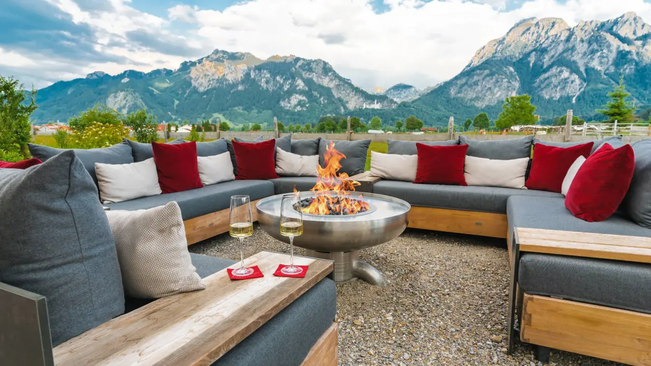 Gemütliche Outdoor-Lounge mit Feuerstelle und Alpenpanorama im Hotel Das Rübezahl. Entspannung unter freiem Himmel.