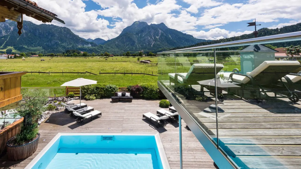 Aussenpool mit Sonnenliegen und atemberaubendem Bergblick auf die Allgäuer Alpen im Hotel Das Rübezahl.
