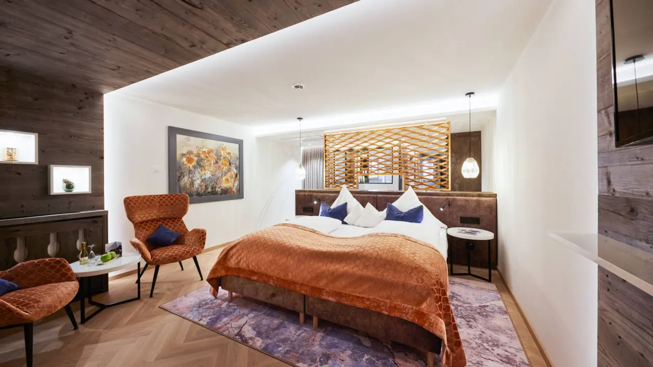 Luxuriöses Doppelzimmer mit Holzelementen und gemütlicher Sitzecke im Hotel Das Rübezahl.