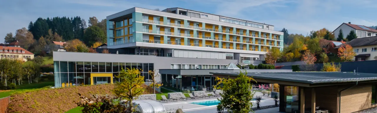 Modernes Hotel Lebensquell mit Aussenpool und Liegebereich, umgeben von herbstlicher Natur und Wald.