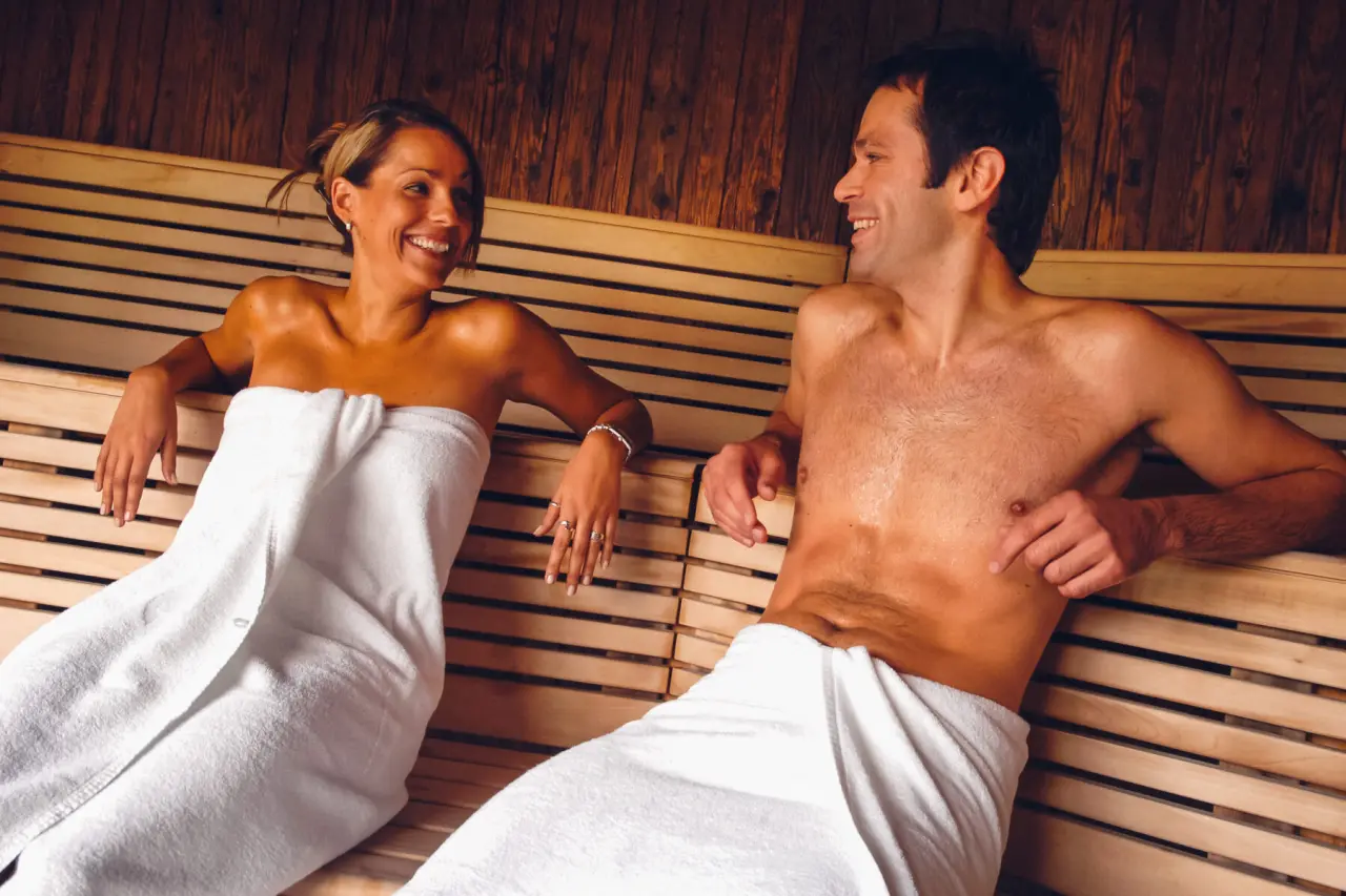 Glückliches Paar entspannt in der finnischen Sauna des Hotel Lebensquell. Warme Atmosphäre für Wellness und Erholung.