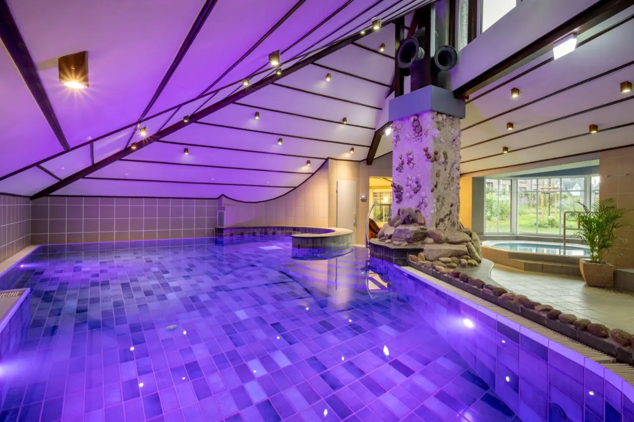 Innenpool mit lila Beleuchtung und Whirlpool im Ringhotel Köhlers Forsthaus