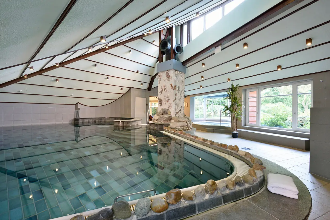 Großzügiger Innenpool mit Tageslicht, Whirlpool und Blick ins Grüne im Ringhotel Köhlers Forsthaus.