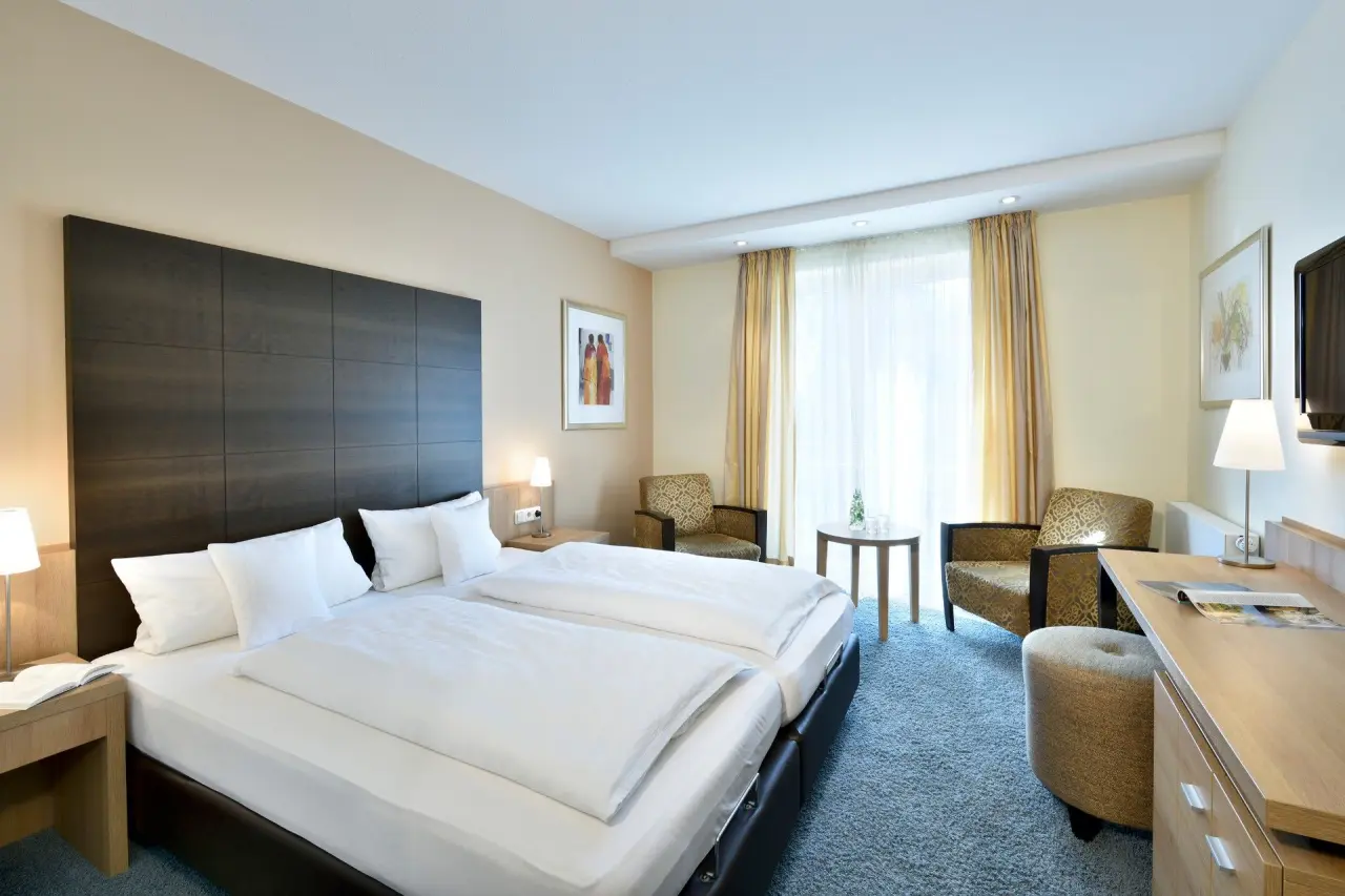 Komfortables Doppelzimmer im Ringhotel Köhlers Forsthaus mit gemütlicher Sitzecke und modernem Interieur.