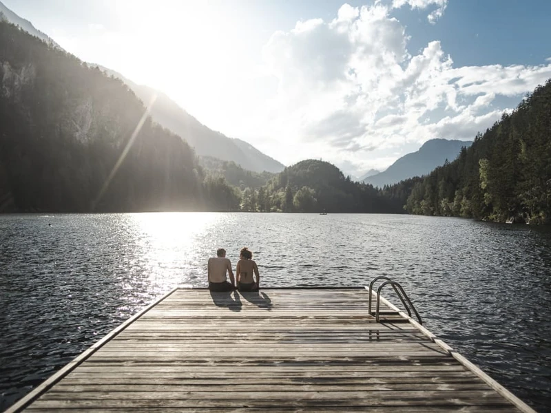 Posthotel Kassl in Oetz – Paar auf einem Steg am See mit Bergpanorama | Wellnesshotel Tirol
