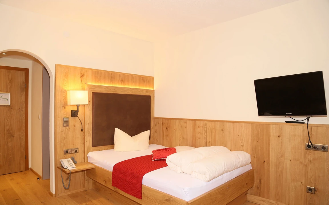 Posthotel Kassl in Oetz – Gemütliches Einzelzimmer mit Holzwand und TV | Wellnesshotel Tirol