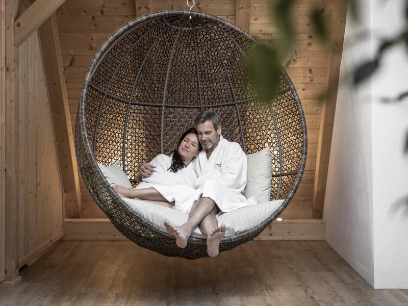 Posthotel Kassl in Oetz – Paar entspannt in einem Hängesessel im Wellnessbereich | Wellnesshotel Tirol