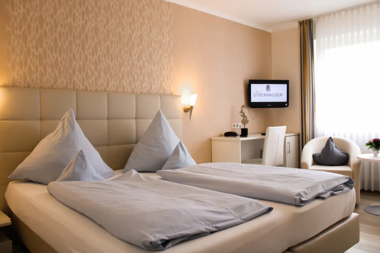 Gemütliches Doppelzimmer mit bequemen Betten, Schreibtisch und TV im Ferienhotel Stockhausen.