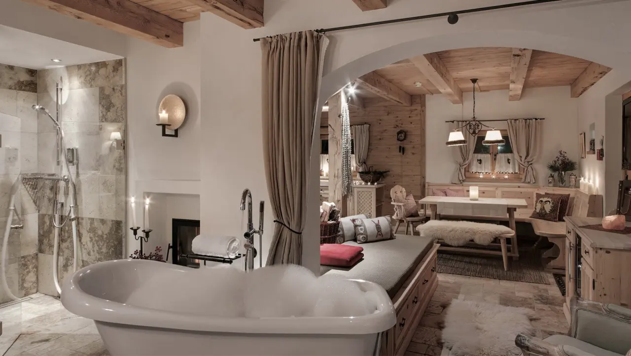Luxuriöses Badezimmer mit freistehender Badewanne und angrenzendem Wohnbereich im INNs HOLZ Chaletdorf.