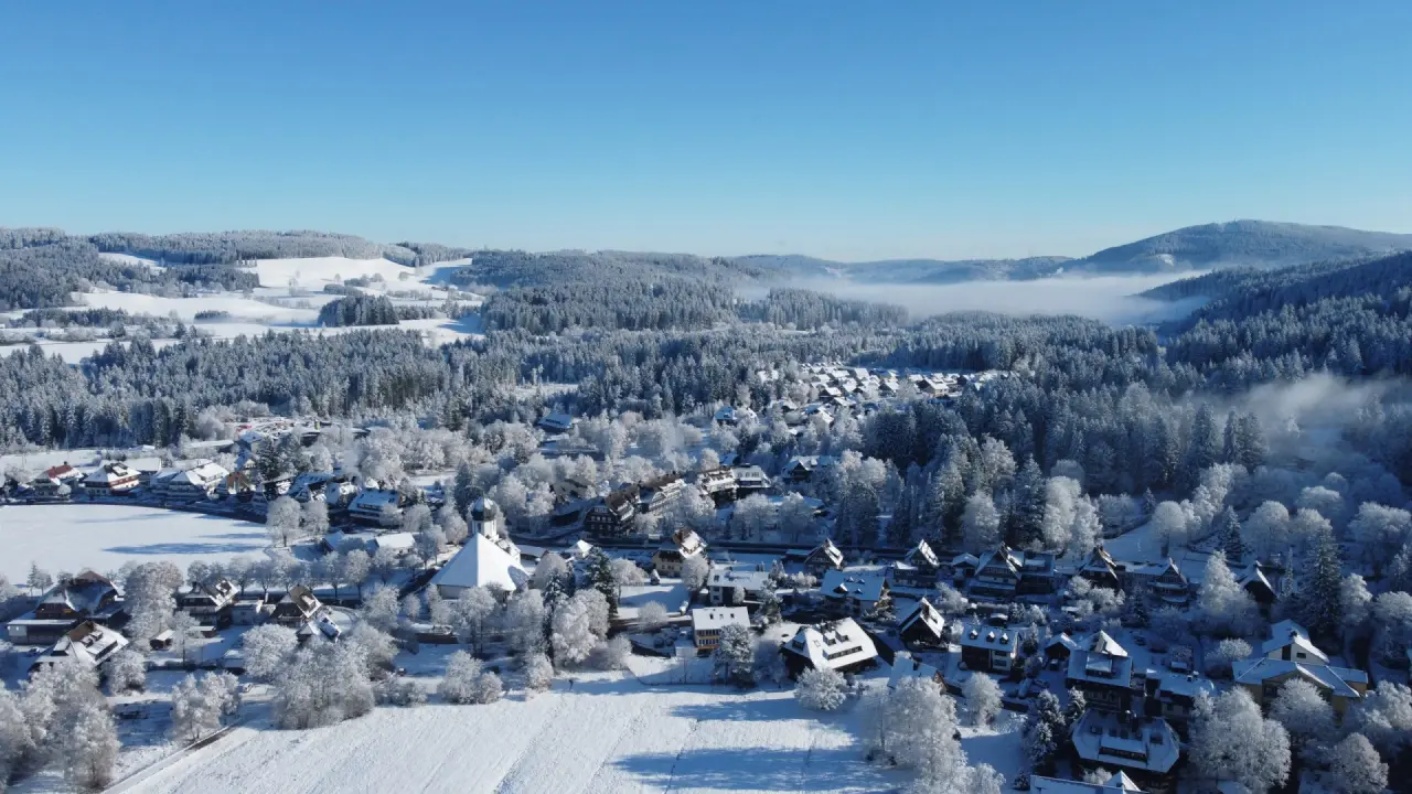 Panoramablick auf das verschneite Dorf und die Winterlandschaft im Schwarzwald. Ideal für Wellness im Hotel Thomahof.