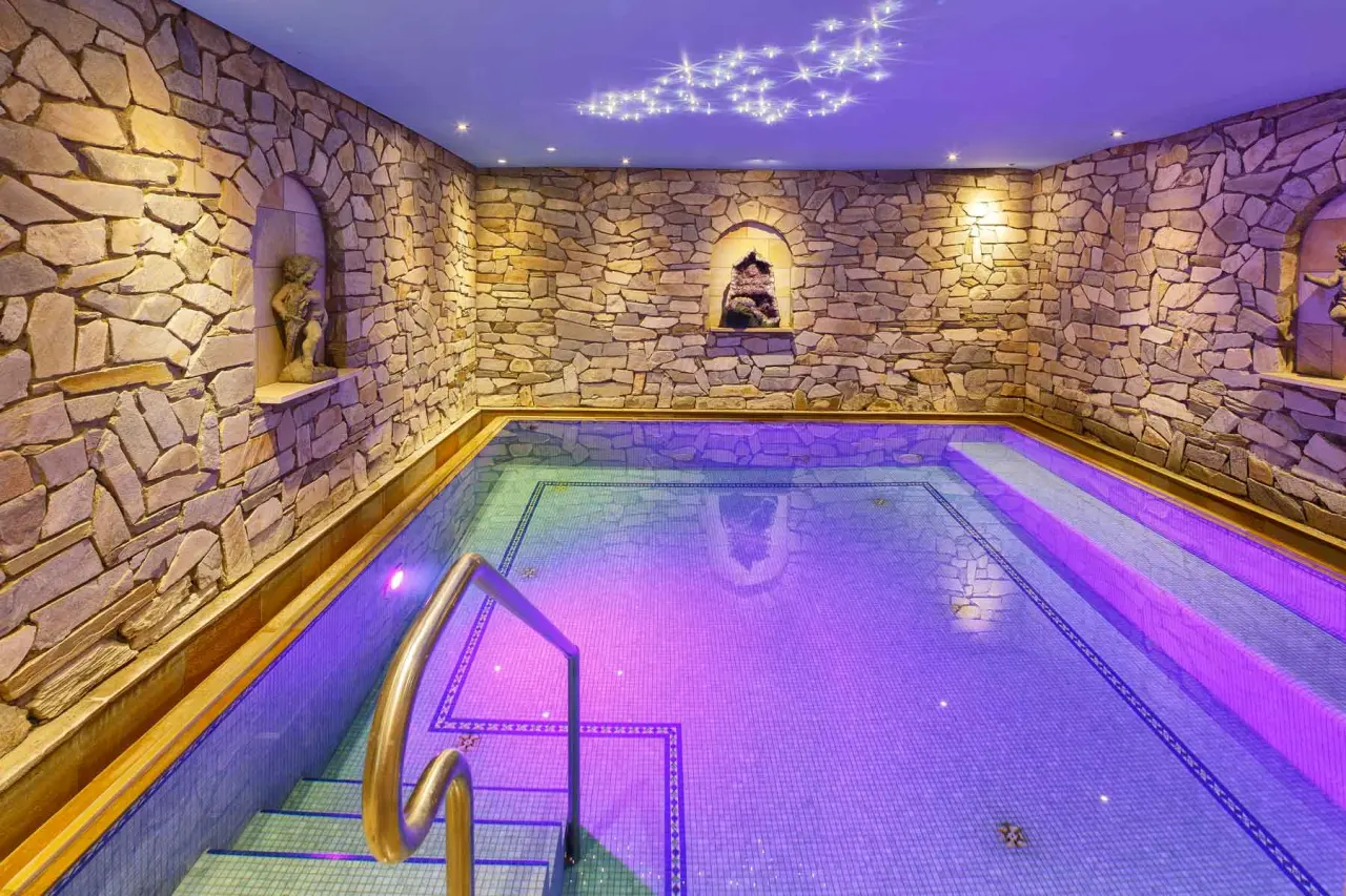 Innenpool mit Steinwänden und Sternenhimmel-Beleuchtung im Wellnessbereich des Hotel Thomahof.