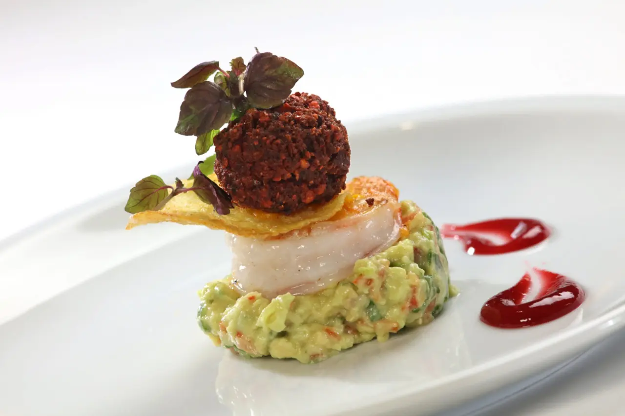 Gourmet-Vorspeise mit Garnele, Avocado und knuspriger Kugel auf weissem Teller im Restaurant des Hotel Thomahof.