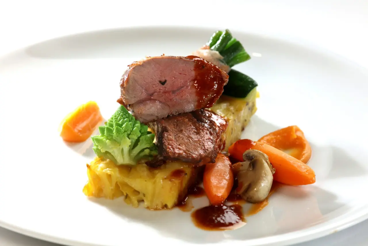 Exquisit angerichteter Hauptgang mit zartem Fleisch und frischem Gemüse im Restaurant des Hotel Thomahof.