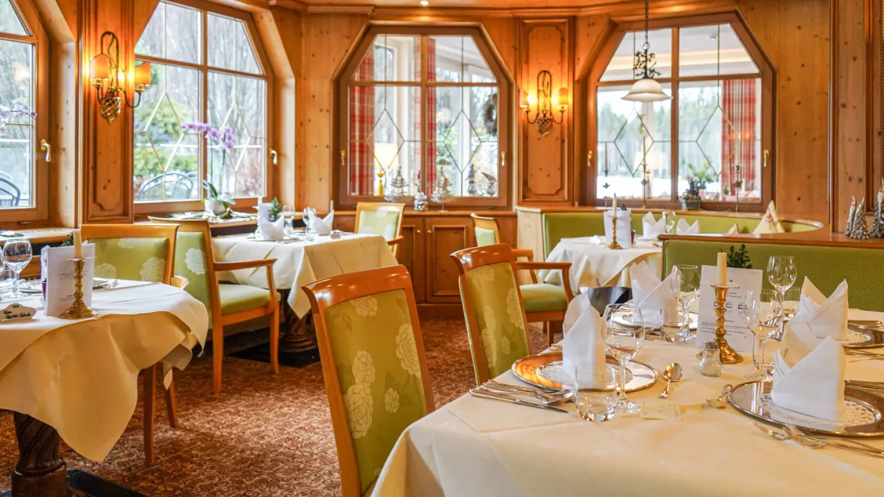 Gemütliches Restaurant im Hotel Thomahof mit traditioneller Holzvertäfelung und festlich gedeckten Tischen.
