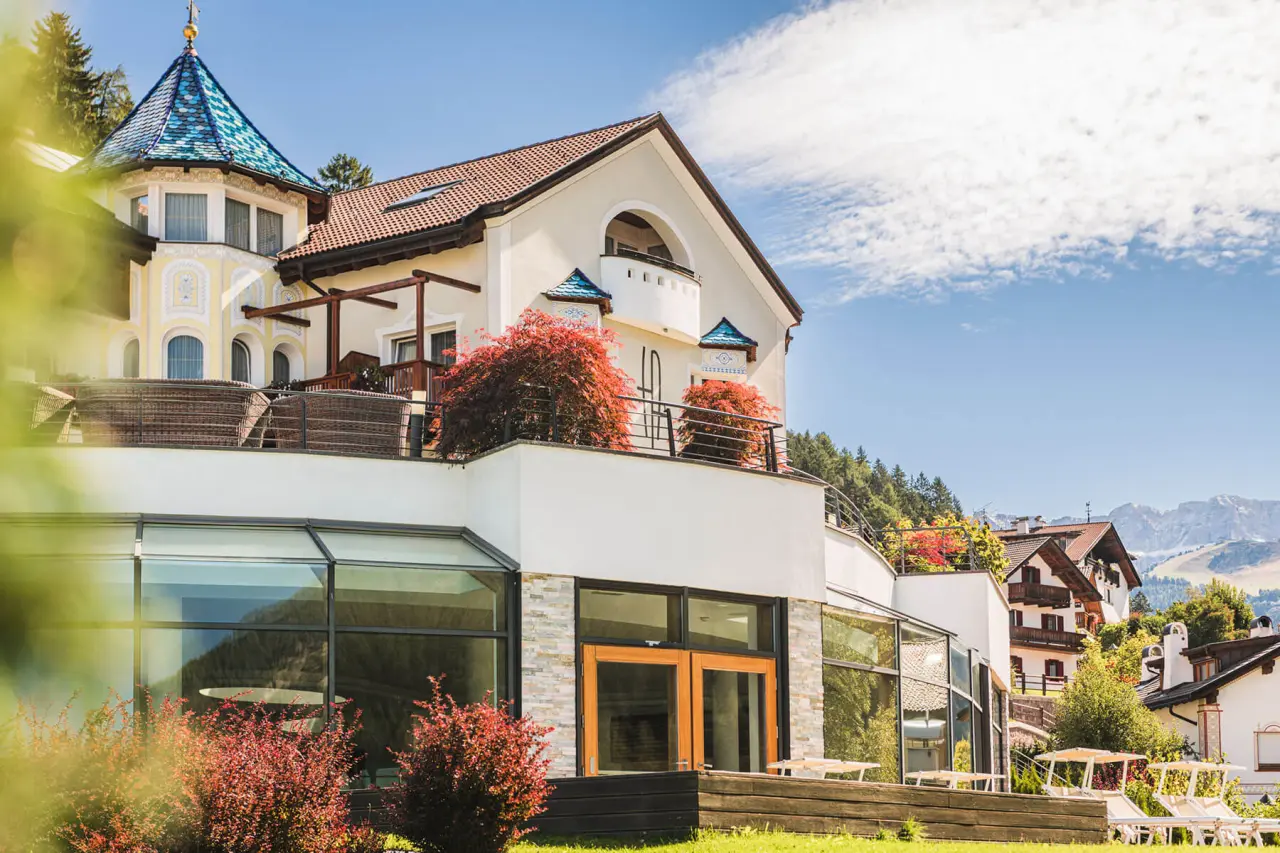 Alpenheim Charming Hotel & Spa in St. Ulrich – Außenansicht mit Sonnenterrasse und Bergpanorama | Wellnesshotel Gröden