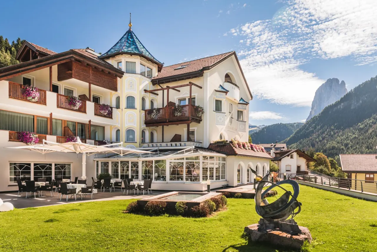 Alpenheim Charming Hotel & Spa in St. Ulrich – Außenansicht mit Garten und Bergblick | Wellnesshotel Gröden