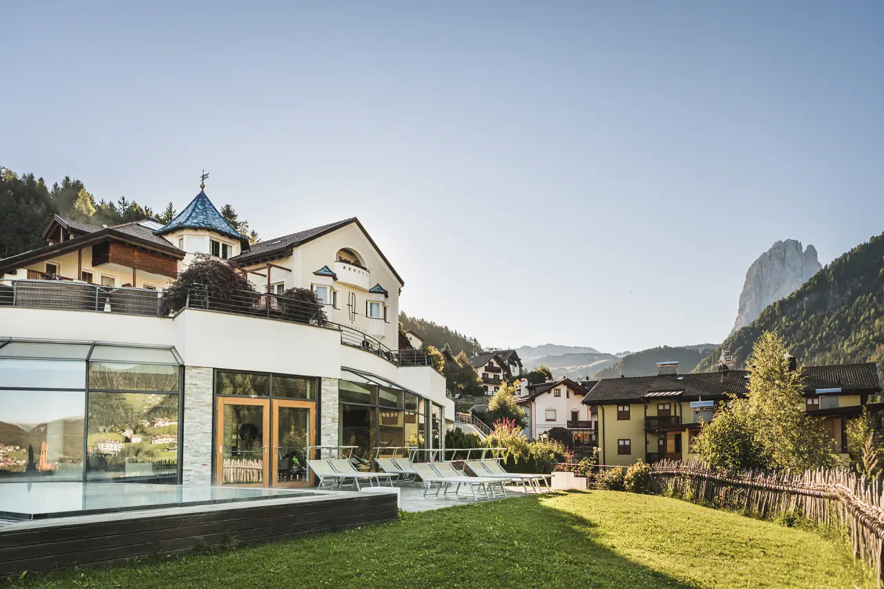 Alpenheim Charming Hotel & Spa in St. Ulrich – Außenansicht mit Pool und Bergblick | Wellnesshotel Südtirol