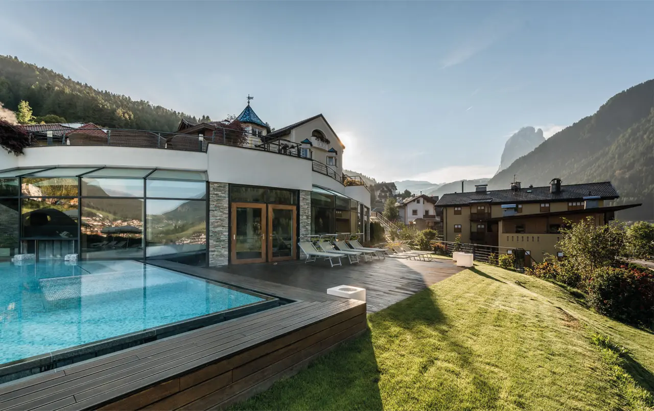 Alpenheim Charming Hotel & Spa in St. Ulrich – Außenpool mit Liegewiese und Bergblick | Wellnesshotel Südtirol