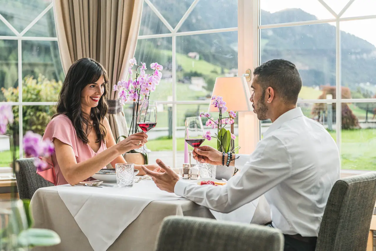 Alpenheim Charming Hotel & Spa in St. Ulrich – Paar beim Abendessen mit Bergblick | Wellnesshotel Südtirol