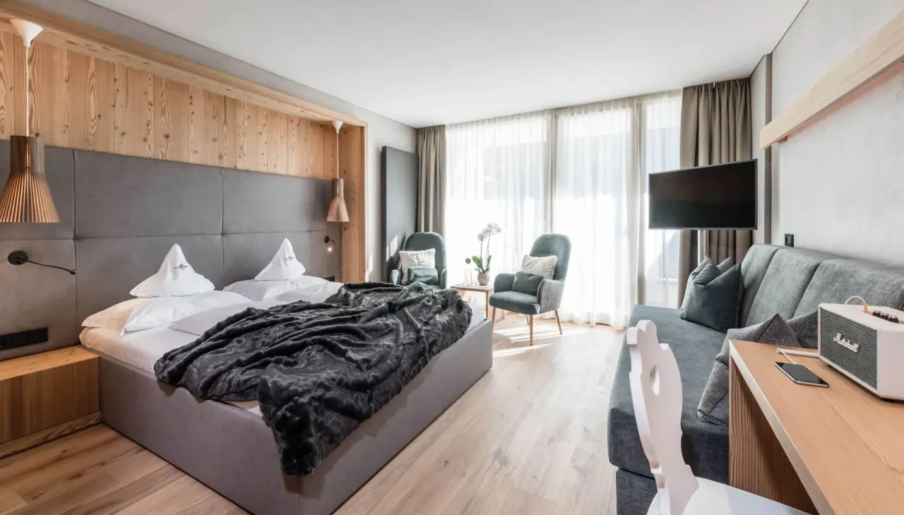 Alpenheim Charming Hotel & Spa in St. Ulrich – Modernes Doppelzimmer mit Altholz und Sitzecke | Wellnesshotel Gröden