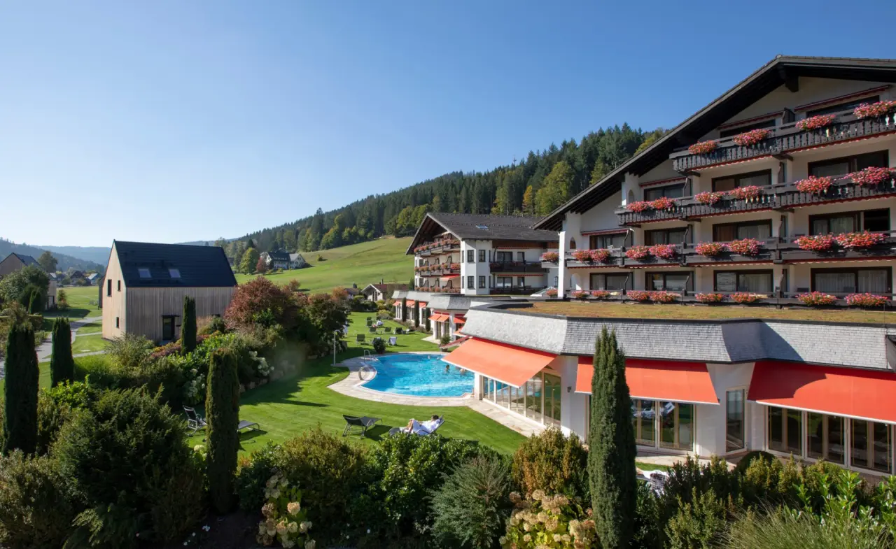 Sonnenverwöhntes Hotel Engel Obertal mit grossem Aussenpool, Liegewiese und idyllischer Schwarzwaldlandschaft.