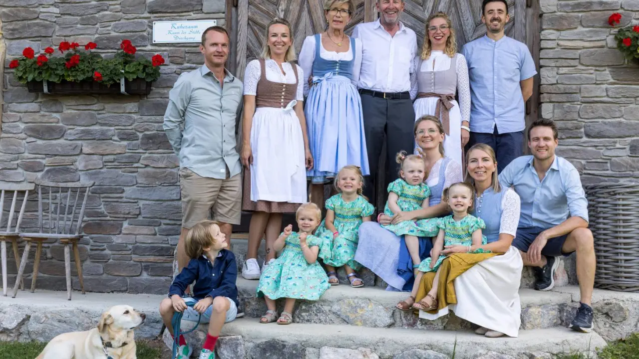 Familienportrait der Gastgeberfamilie vor dem Ruheraum des Alpin Family Resort Seetal****s