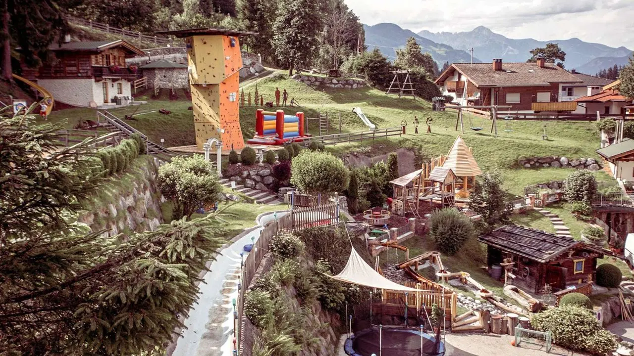 Umfangreicher Abenteuerspielplatz mit Kletterturm, Trampolin und Rutschen im Alpin Family Resort Seetal.
