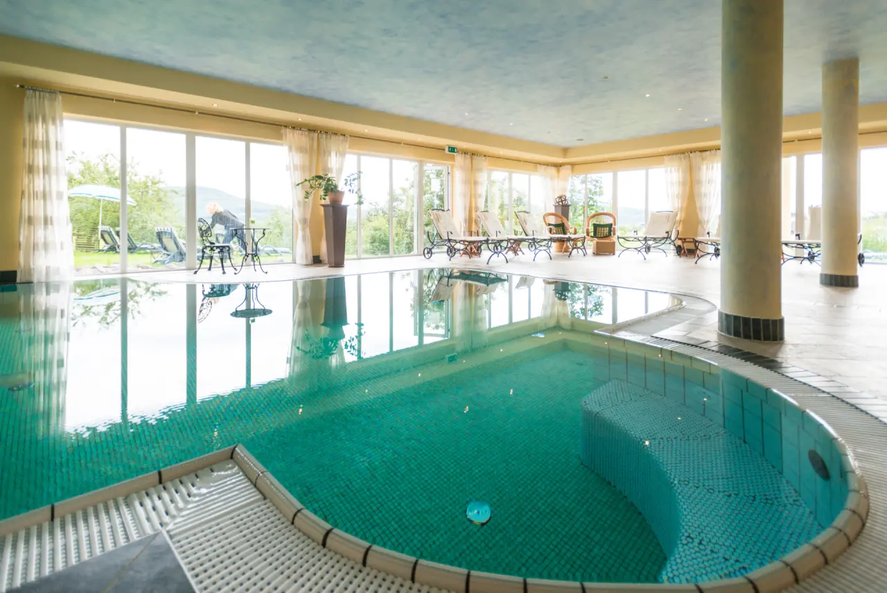 Innenpool mit Tageslicht und Liegebereich im Natur- & Wohlfühlhotel Kastenholz