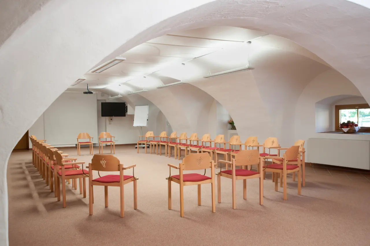 Historischer Tagungsraum mit Gewölbedecke und Holzstühlen im Hotel Althof Retz, ideal für Seminare und Meetings.