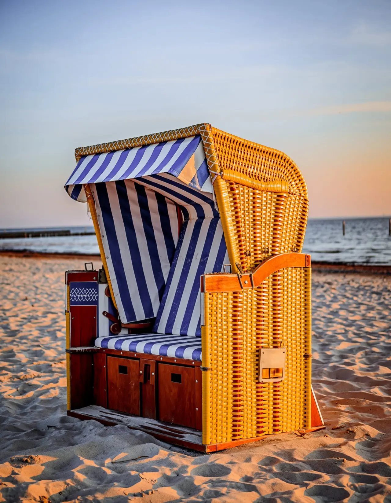 Strandkorb am Strand von Duhnen bei Sonnenuntergang, ideal für Entspannung im Strandhotel Duhnen.