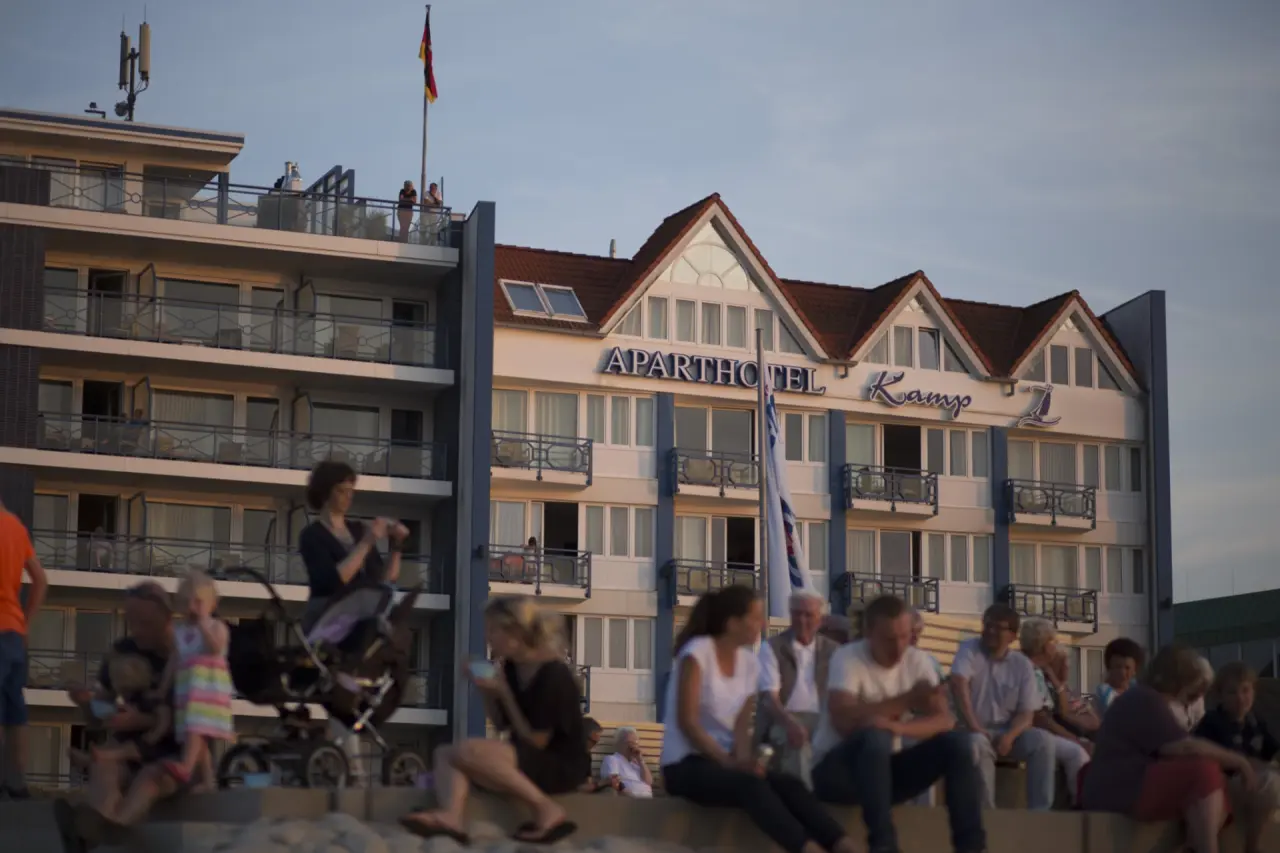 Aussenansicht des Aparthotel Kamp bei Sonnenuntergang mit Balkonen und Dachgiebeln.