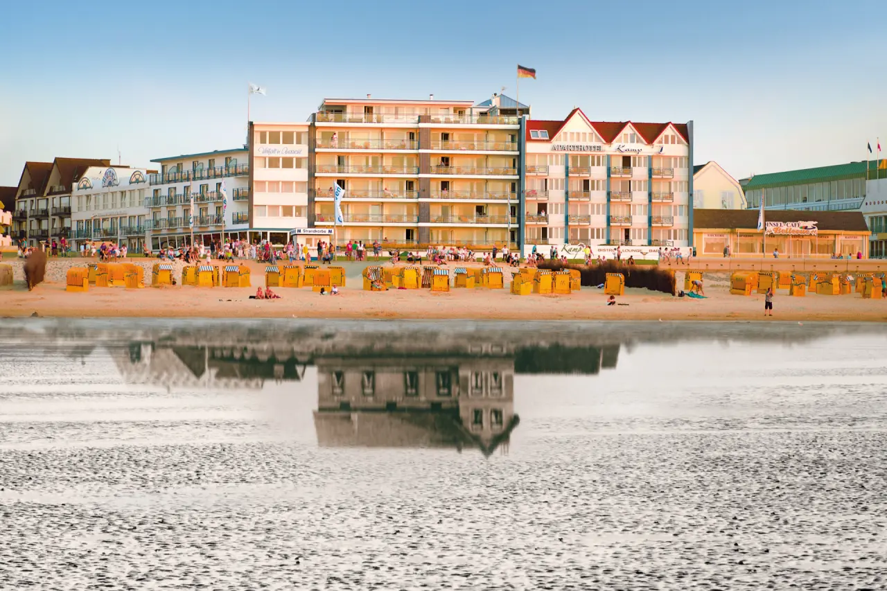 Panoramablick auf das Strandhotel Duhnen mit Strandkörben am Sandstrand und der Nordsee bei Ebbe.