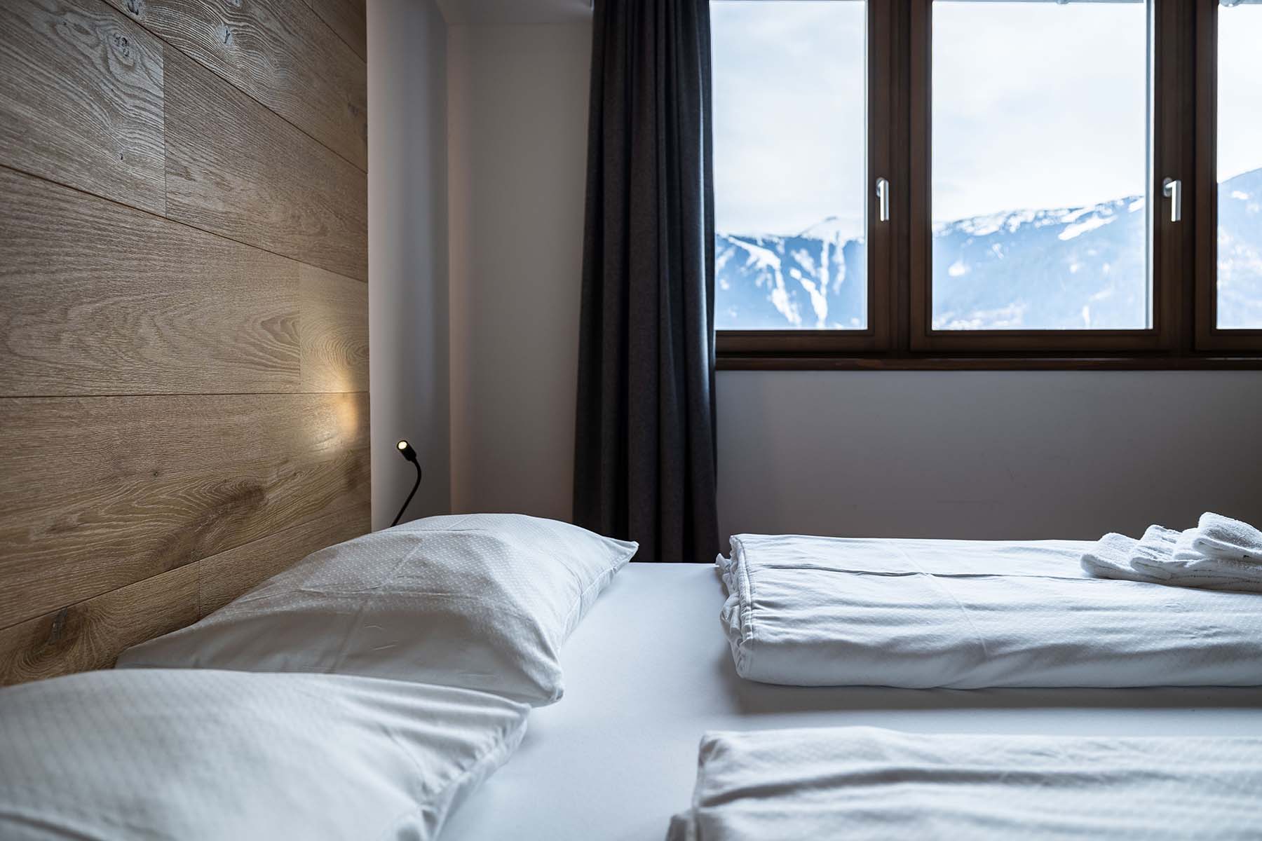 Seehotel Bellevue in Zell am See – Komfortables Doppelzimmer mit Blick auf die verschneiten Berge | Wellnesshotel Salzburger Land