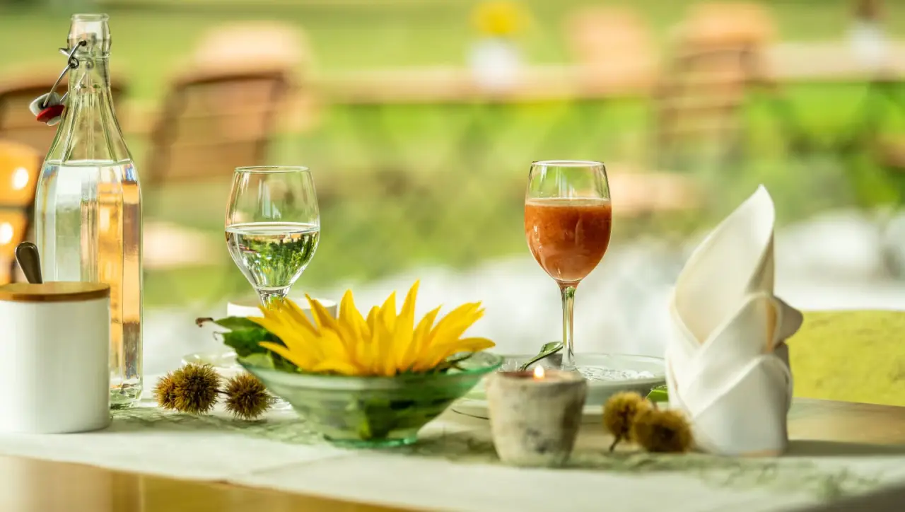 Tischdekoration mit frischen Getränken und Sonnenblume im Restaurant des Menschels Vitalresort.