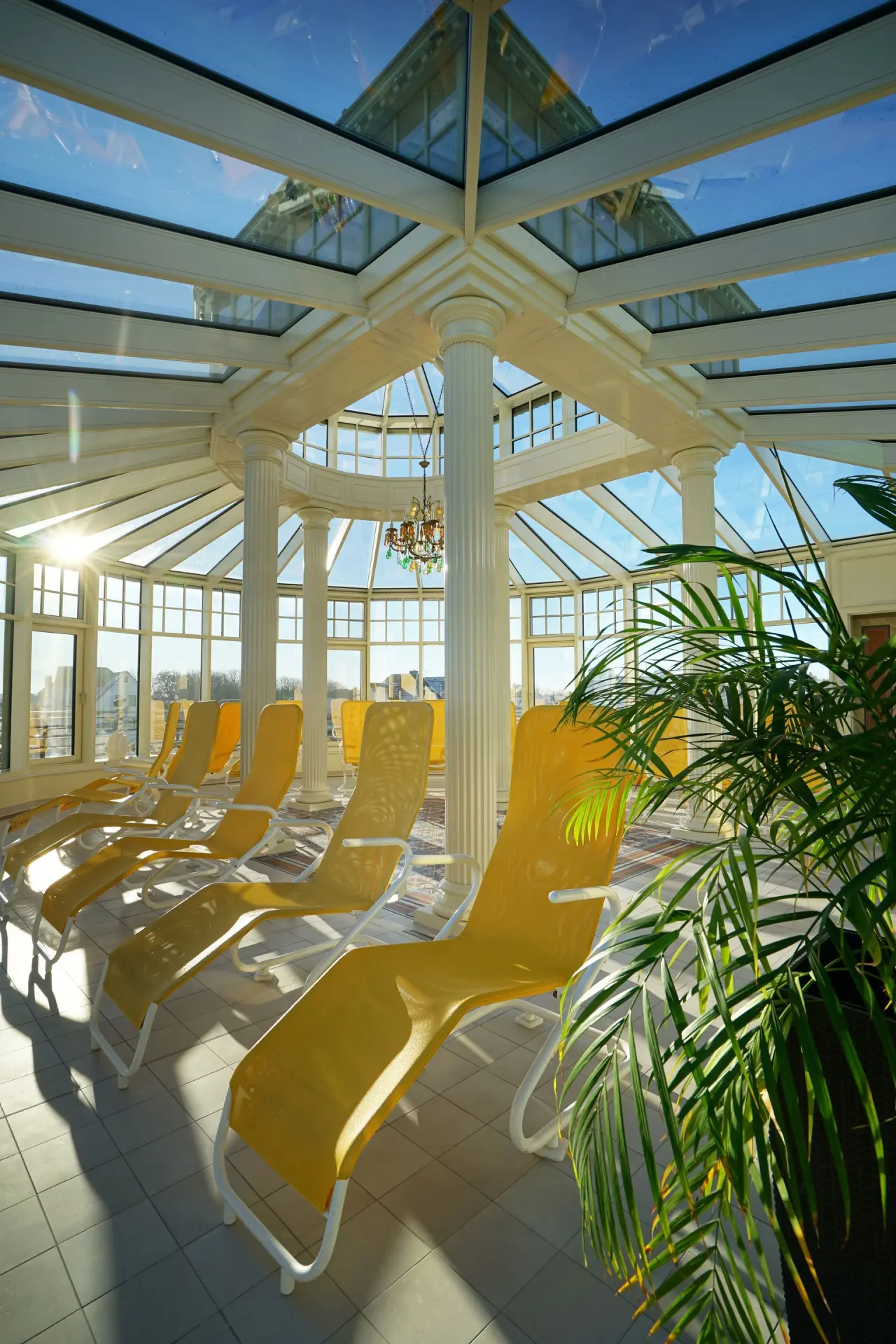 Heller Ruheraum mit gelben Liegen und Glasdach im Wellnessbereich des Hotel Strandperle.
