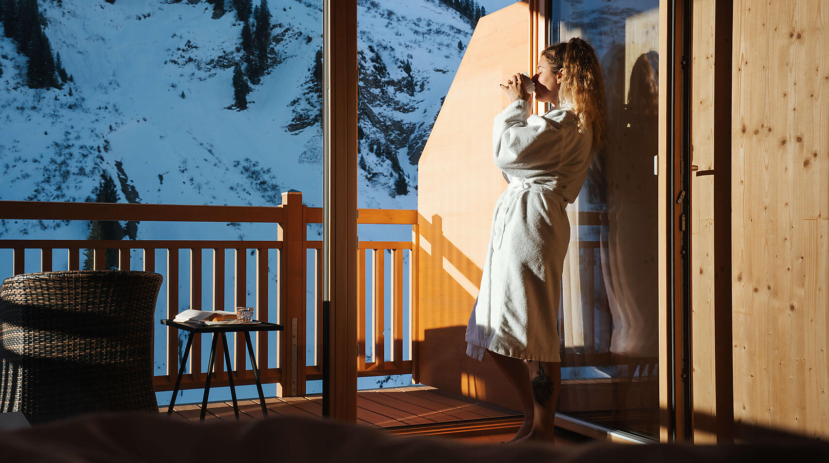 Damülser Hof in Damüls – Frau im Bademantel auf dem Balkon mit Bergblick | Wellnesshotel Vorarlberg