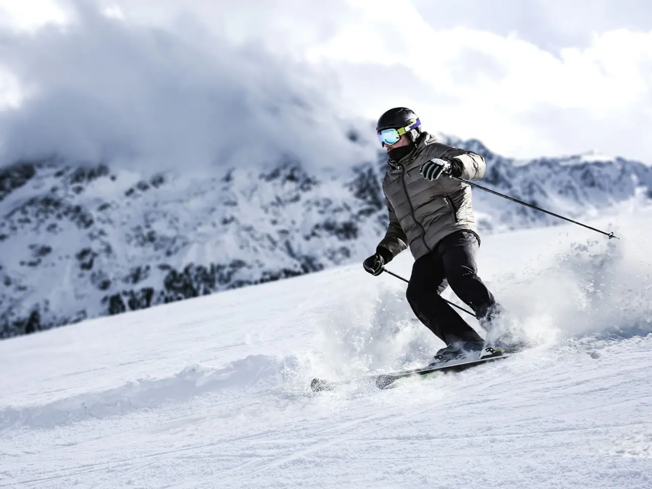 Dynamischer Skifahrer auf der Piste in Davos mit Bergpanorama, ideal für Gäste des Precise Tale Seehof Davos.