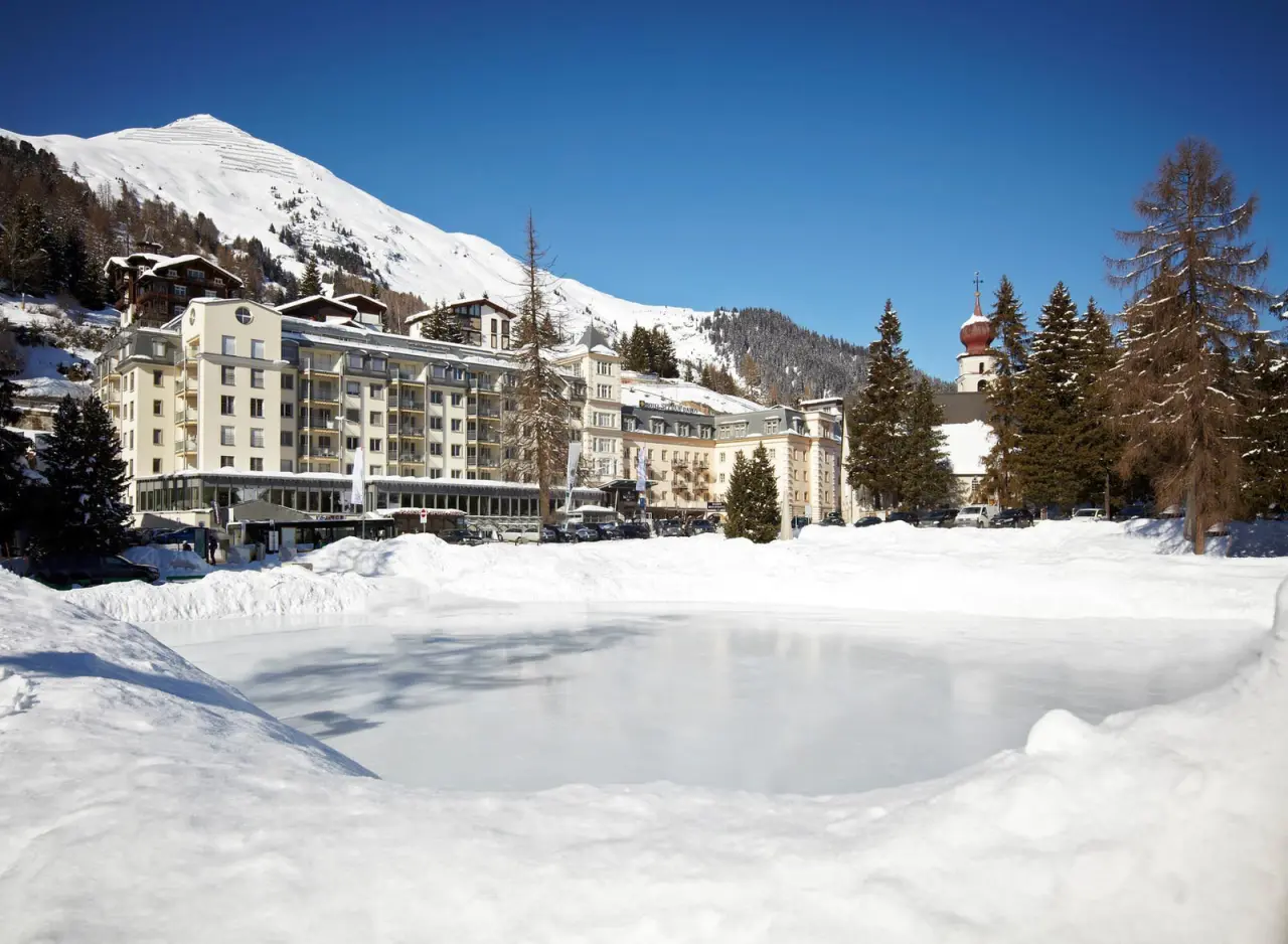 Winteransicht des Precise Tale Seehof Davos mit verschneiter Berglandschaft und zugefrorenem See in Davos.