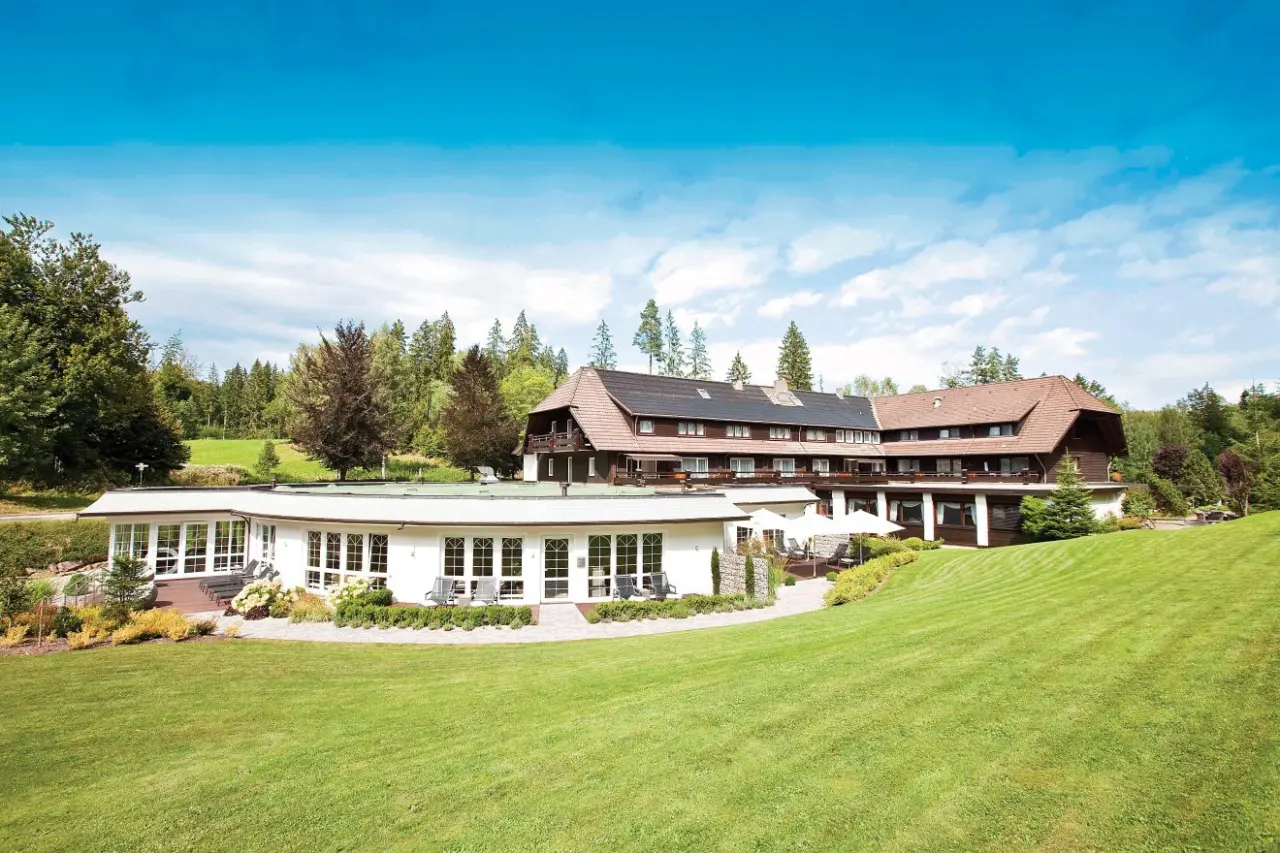 Aussenansicht des Hotel Waldsägmühle mit traditioneller Architektur, umgeben von Wald und grünen Wiesen.