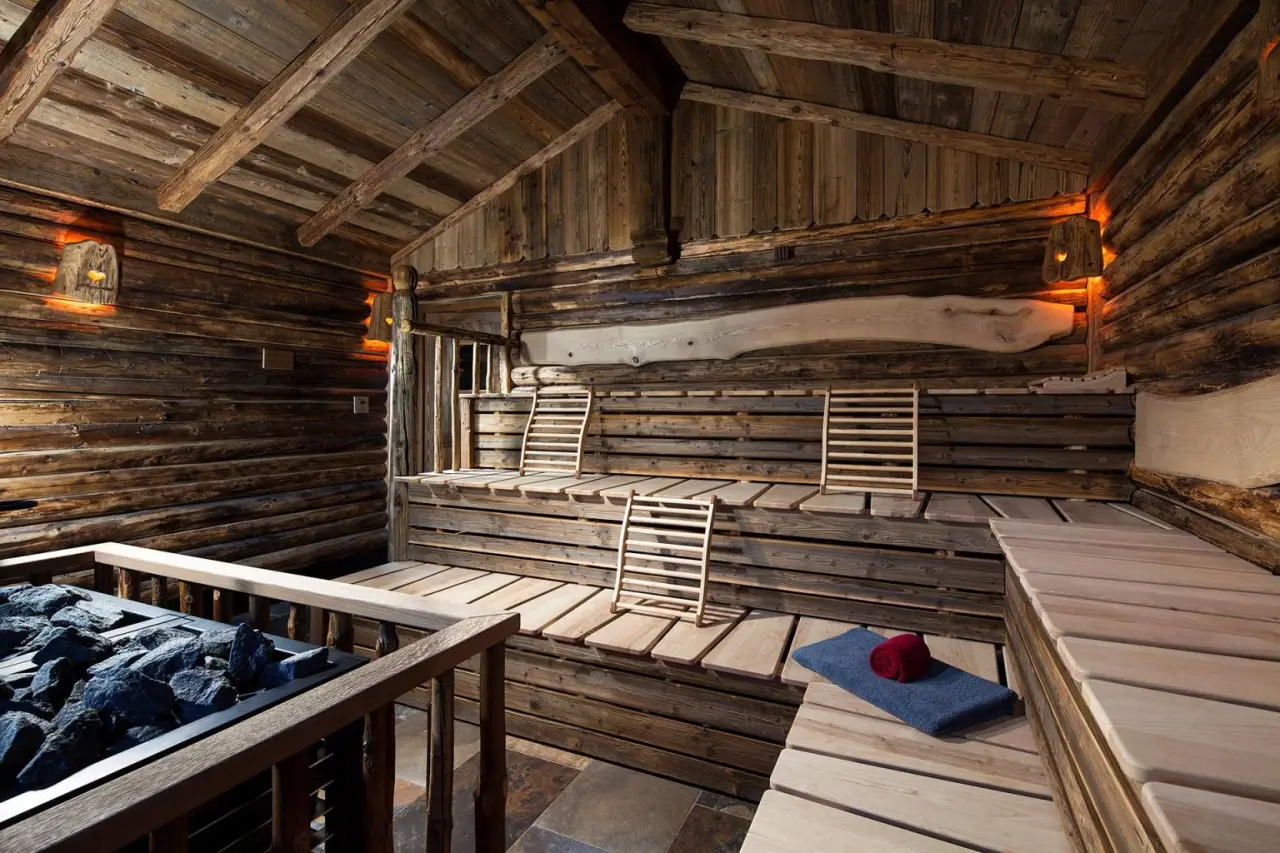 Rustikale Finnische Sauna mit Holzvertäfelung und warmem Licht im Alm- & Wellnesshotel Alpenhof.